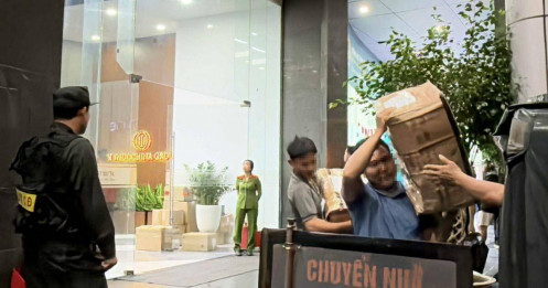 Cảnh sát vận chuyển nhiều thùng niêm phong ra khỏi tòa nhà có trụ sở công ty Shark Bình
