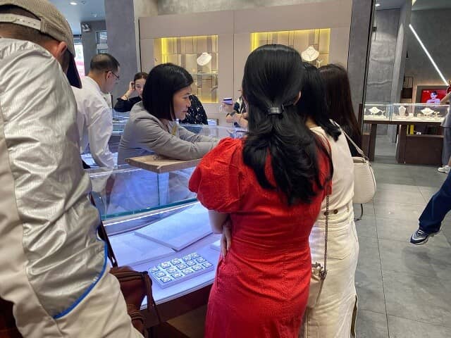 Khách hàng mua vàng PNJ chờ thanh toán tại quầy. Với niềm tin mua vàng vào ngày vía Thần tài (mùng 10  ...