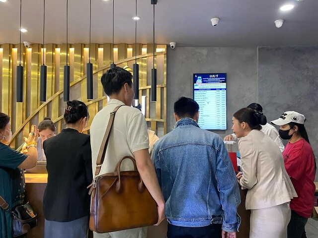 Khách hàng mua vàng PNJ chờ thanh toán tại quầy. Với niềm tin mua vàng vào ngày vía Thần tài (mùng 10  ...